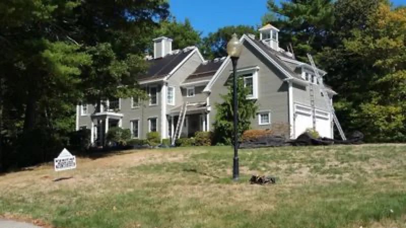 Veritas Roofing crew re-roofing a large colonial home