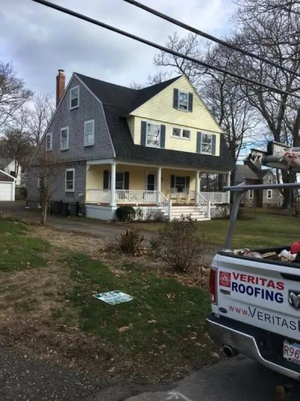Veritas Roofing truck parked in front of a completed roofing job
